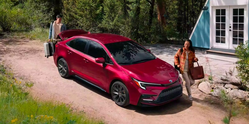 Two people packing up their 2024 Toyota Corolla Hybrid for the holidays in Akron, OH
