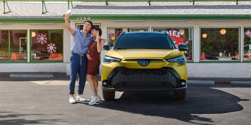 A the 2024 Toyota Corolla Cross Hybrid posing for a selfie amongst its versatility in Akron, OH