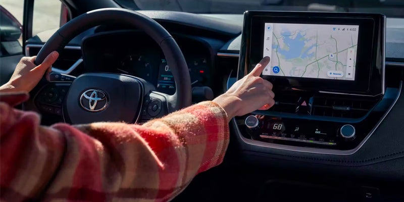 A driver using the safety features available in the 2024 Toyota Corolla in Akron, OH