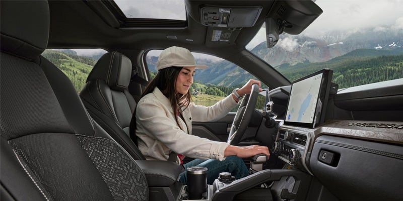 A driver manipulating the safety features in the 2024 Toyota Tacoma in Akron, OH