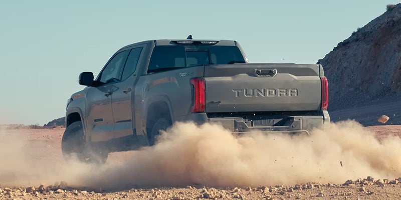 A 2024 Toyota Tundra kicking up dust as it drives in Akron, OH
